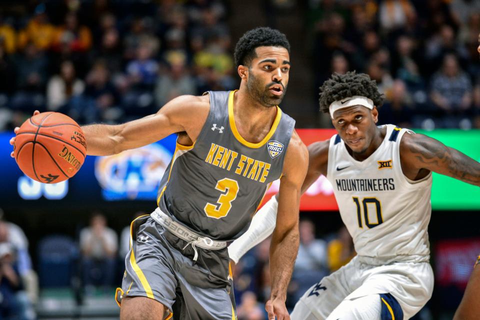 FILE - Kent State guard Sincere Carry (3) protects the ball from West Virginia guard Malik Curry (10) during the second half of an NCAA college basketball game in Morgantown, W.Va., Sunday, Dec. 12, 2021. Kent State's strong season in the Mid-American Conference has been rewarded with junior guard Sincere Carry being named the league's top player and Rob Senderoff winning coach of the year honors, Wednesday, March 9, 2022. (AP Photo/William Wotring, File)