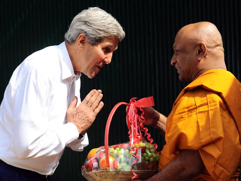 US Secretary of State John Kerry (L) greets Kollupitiye Mahinda Sangharakkhita mahathera at the Kelaniya Rajamaha temple during a visit to Kelaniya on May 2, 2015