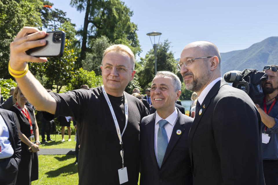 Swiss President Ignazio Cassis, Minister of Foreign Affairs, center, and Ukrainian Prime Minister Denys Shmyhal, right, pose for a photo with Andriy Sadovyy, Mayor of Lviv, left, during the Ukraine Recovery Conference URC, on Tuesday, July 5, 2022 in Lugano, Switzerland. The URC is organised to initiate the political process for the recovery of Ukraine after the attack of Russia to its territory. (Michael Buholzer/Keystone via AP)