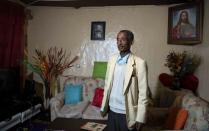 Ayalew Wedajo poses for a photograph inside his house during an interview with Reuters in Addis Ababa