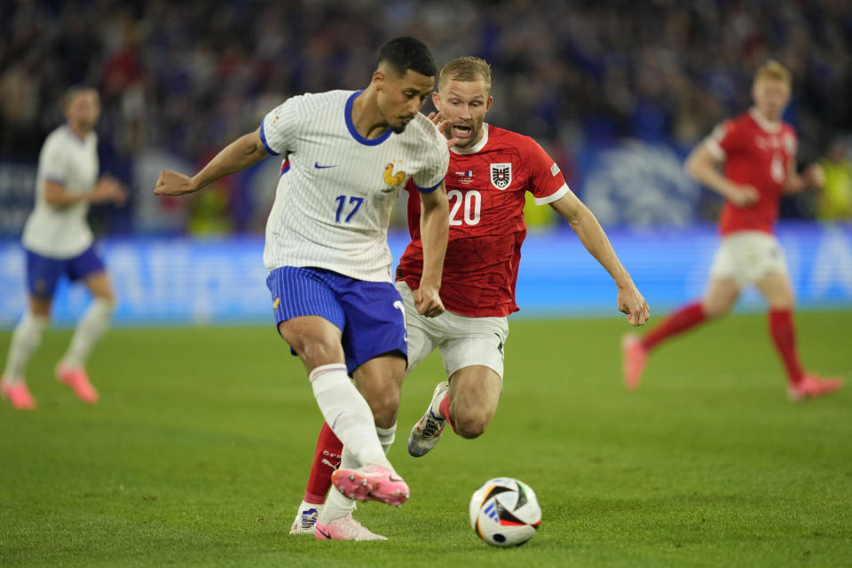 Austria's Konrad Laimer challenges for the ball with William Saliba of France during a Group D match between Austria and France at the Euro 2024 soccer tournament in Duesseldorf, Germany, Monday, June 17, 2024. (AP Photo/Andreea Alexandru)