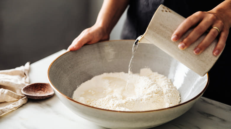 Pouring water into flour