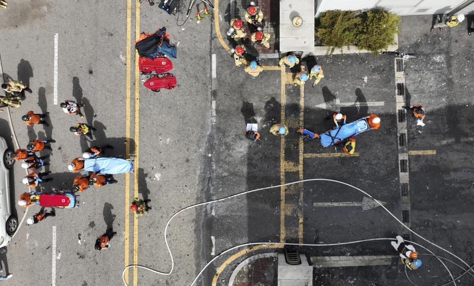 Firefighters carry bodies at the site of a fire at a lithium battery manufacturing factory in Hwaseong, South Korea, Monday, June 24, 2024. (Newsis via AP)