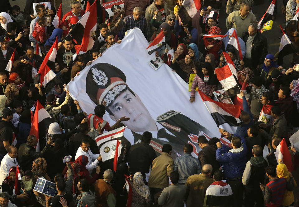 FILE - In this Saturday, Jan. 25, 2014 file photo, Egyptians wave a giant poster of Egypt's Defense Minister, Gen. Abdel-Fattah el-Sissi in Tahrir Square, the epicenter of the 2011 uprising, in Cairo, Egypt. The head of Egypt’s military, Abdel-Fattah el-Sissi, is riding on a wave of popular fervor that is almost certain to carry him to election as president. Unknown only two years ago, a broad sector of Egyptians now hail him as the nation’s savior after he ousted the Islamists from power, and the state-backed personality cult around him is so eclipsing, it may be difficult to find a candidate to oppose him if he runs. Still, if he becomes president, he faces the tough job of ruling a deeply divided nation that has already turned against two leaders. (AP Photo/Amr Nabil, File)