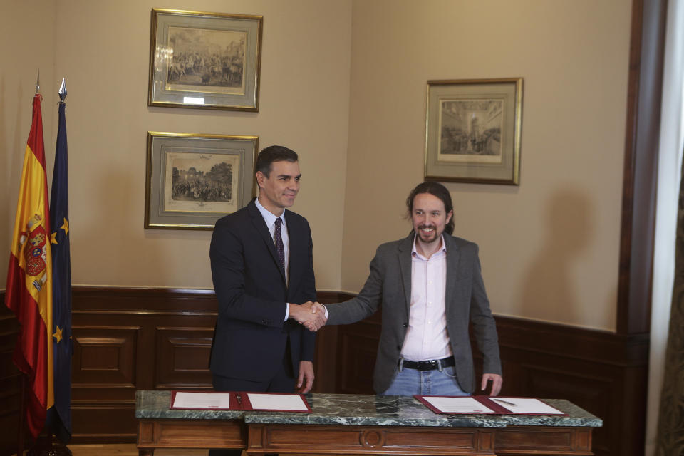 Spain's caretaker Prime Minister Pedro Sanchez, left, and Podemos party leader Pablo Iglesias shake hands after signing an agreement at the parliament in Madrid, Spain, Tuesday, Nov. 12, 2019. The leaders of Spain's Socialist party and the left-wing United We Can (Podemos) party say they have reached a preliminary agreement toward forming a coalition government. But the deal announced Tuesday won't provide enough votes in parliament for the Socialists, who won a general election, to take office without the support of other parties. (AP Photo/Paul White)