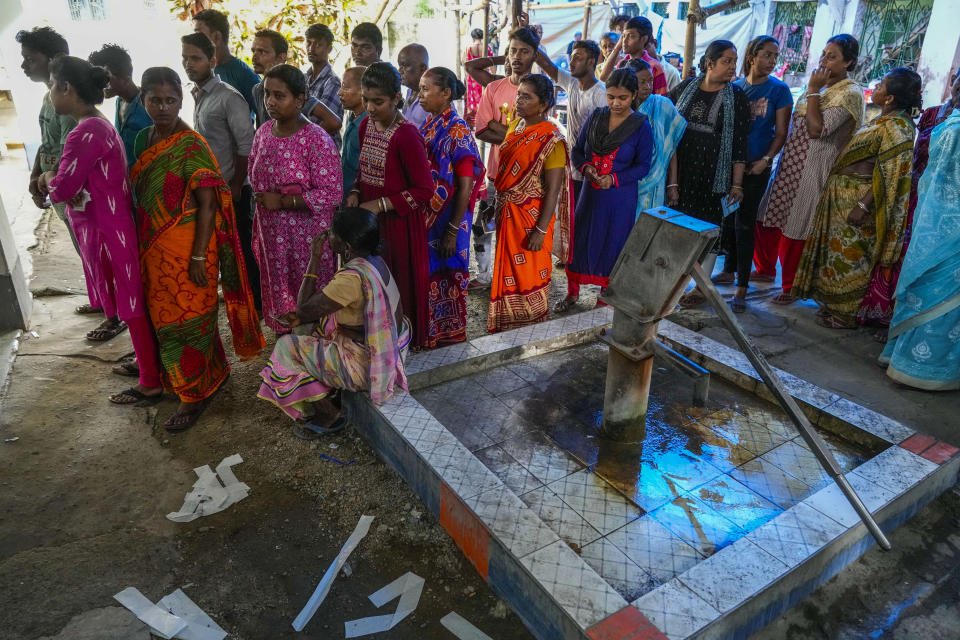 People queue up to vote next to a hand pump outside a polling booth during the fifth round of multi-phase national election in Howrah, India, Monday, May 20, 2024. (AP Photo/Bikas Das)