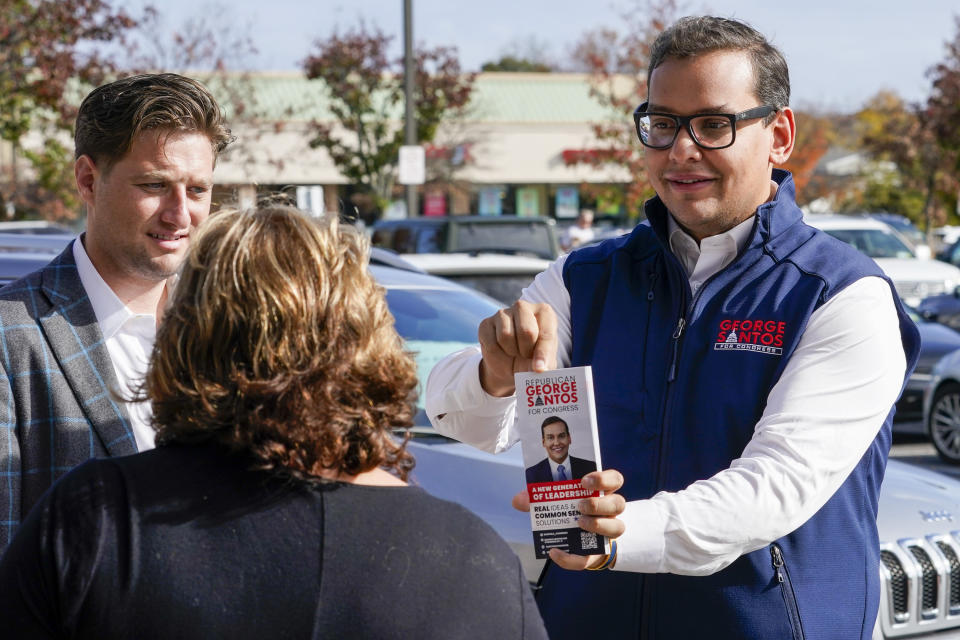 Then–Republican candidate George Santos (right) talks to a voter while campaigning outside a Stop & Shop store on Nov. 5 in Glen Cove, New York.
