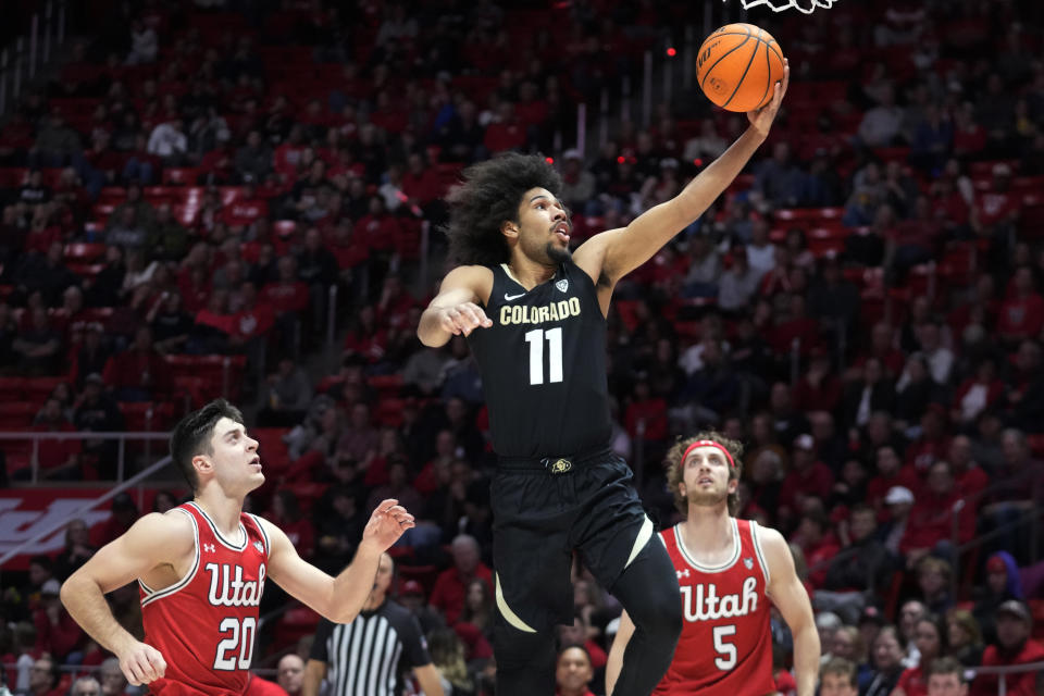 Colorado guard Javon Ruffin (11) goes to the basket as Utah's Lazar Stefanovic (20) and Jaxon Brenchley (5) watch during the first half of an NCAA college basketball game Saturday, Feb. 11, 2023, in Salt Lake City. (AP Photo/Rick Bowmer)