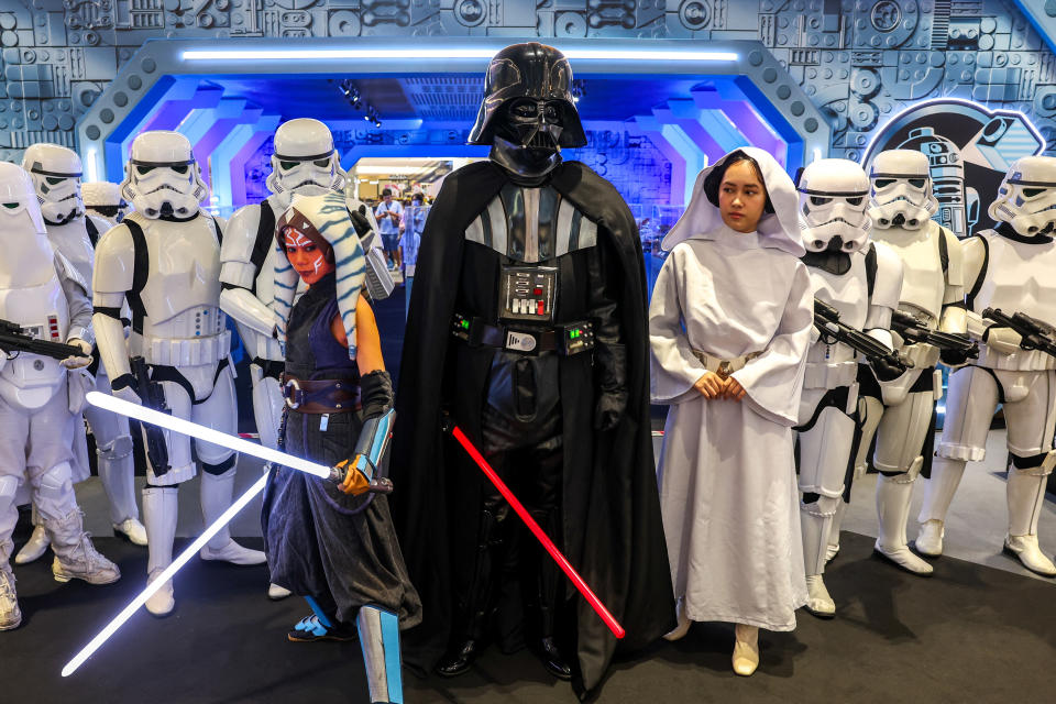 Fans in Darth Vader and stormtrooper costumes pose in Bangkok.