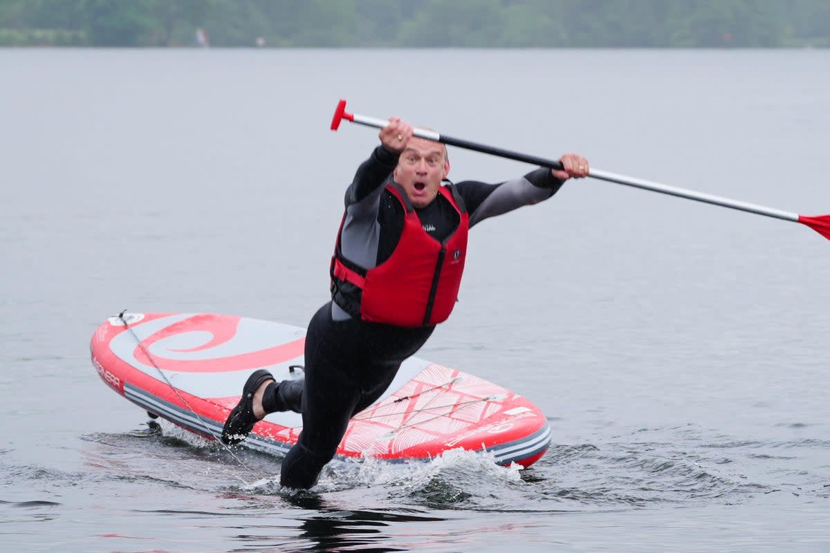 Liberal Democrat Leader Sir Ed Davey falls into the water while paddleboarding on Lake Windermere (Peter Byrne/PA) (PA Wire)