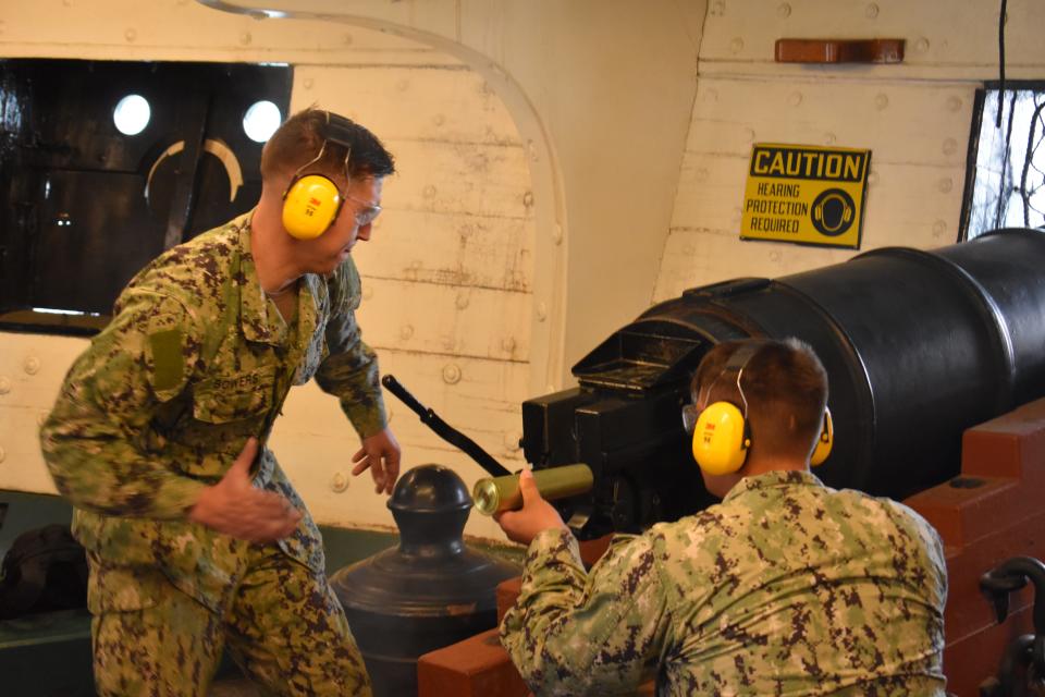 Sailors fire the cannons during a 21-gun salute.