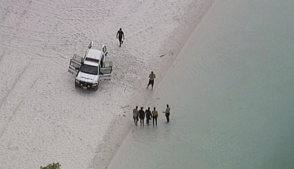 In this image made from video, police divers at Lake McKenzie in Queensland, New Zealand, Saturday, March 30, 2019.(Australian Broadcasting Corporation via AP)