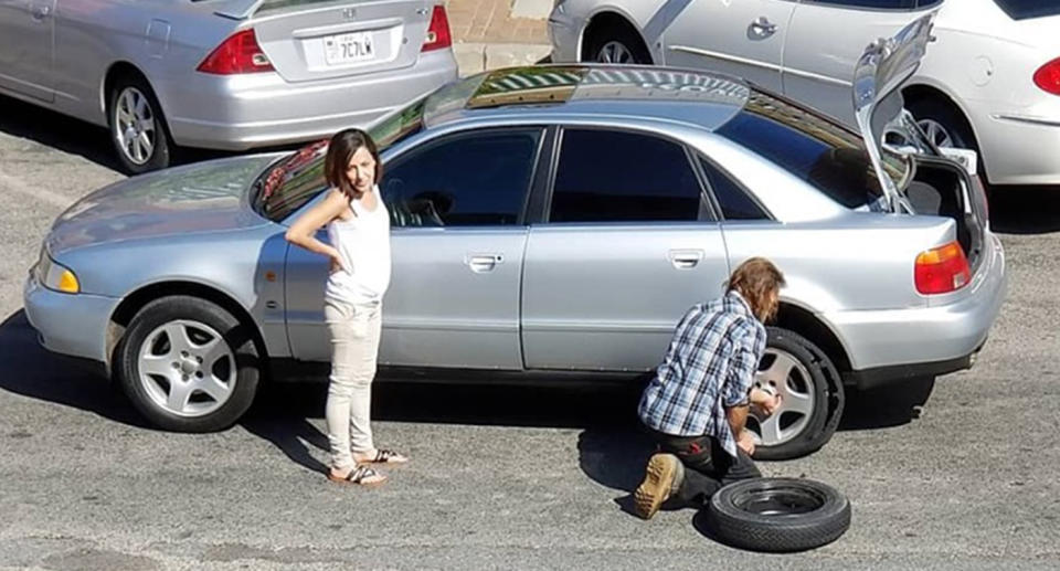 Utah homeless man Chuck helps a woman with her blown-out tyre on her car.