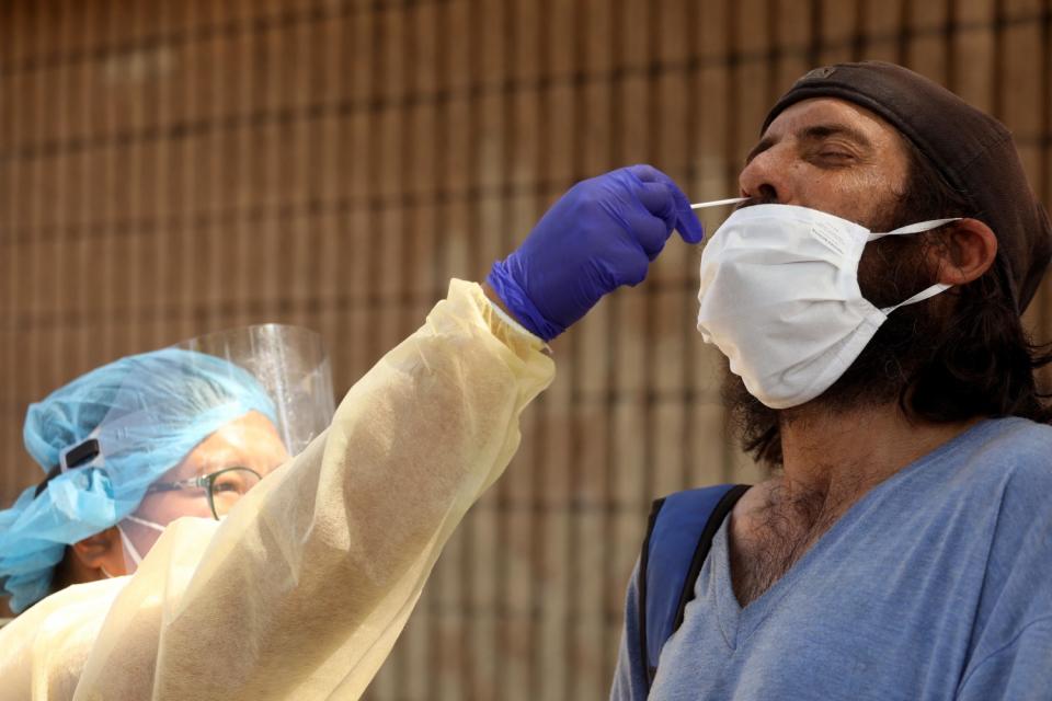 Nurse Richelle Legaspi gives Gonzalo Cresci, who is homeless, a test for COVID-19 in East Hollywood