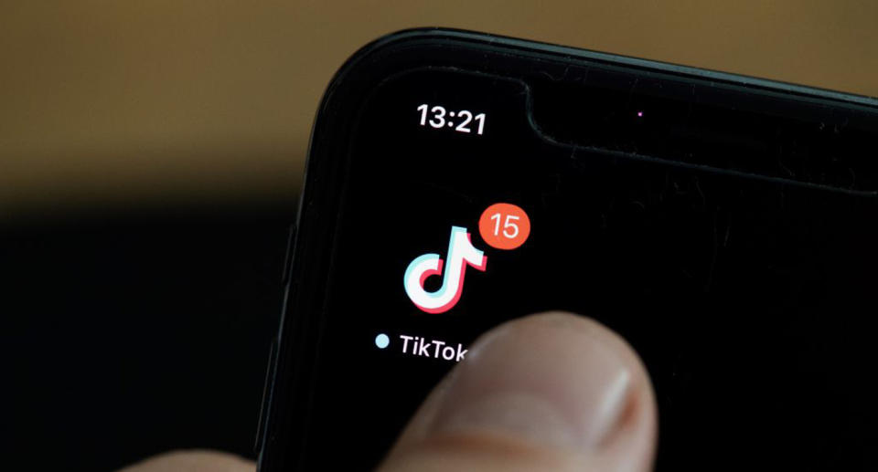 Pictured is a TikTok app icon on a smartphone. 