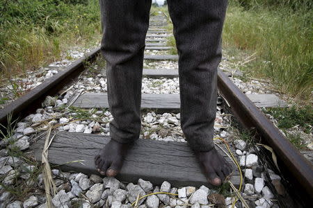 26-year-old Azam from South Sudan stands on rail tracks after failing to flee to Italy in the western Greek town of Patras April 28, 2015. REUTERS/Yannis Behrakis