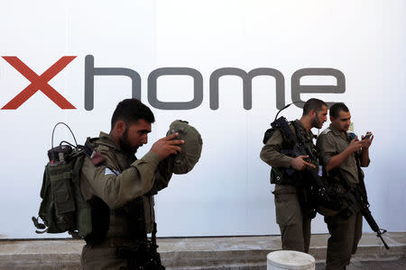 An Israeli soldier puts on his helmet as he patrols the scene of a stabbing attack near a mall in the Gush Etzion Junction in the occupied West Bank, September 16, 2018. REUTERS/Ronen Zvulun