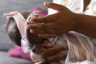 Asian Davis, 33, of Sikeston, Mo., cradles her 8-month-old daughter Mira White, during an interview on Oct. 3, 2023, in St. Louis. Davis and her lawyers say Mira suffered brain damage in March after developing bacterial meningitis tied to powdered infant formula contaminated with Cronobacter sakazakii, a germ known to cause severe disease in young babies. (AP Photo/Michael Thomas)