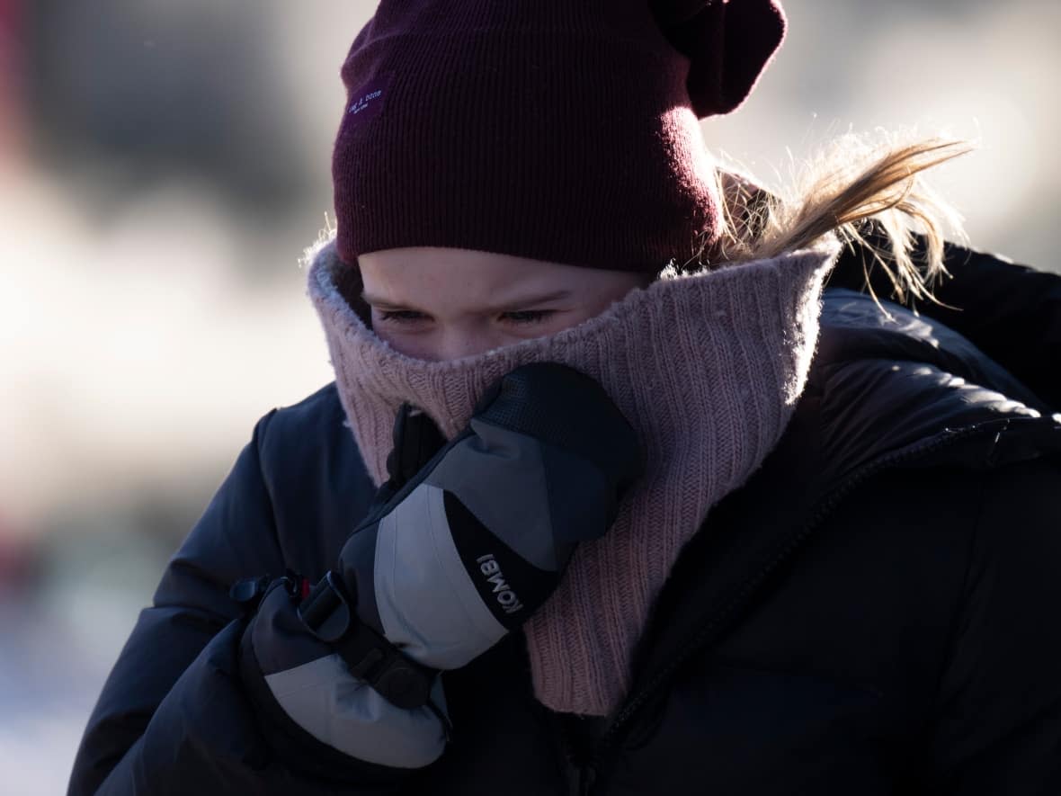 A person tries to stay warm as they walk in downtown Ottawa on Friday. (Adrian Wyld/The Canadian Press - image credit)