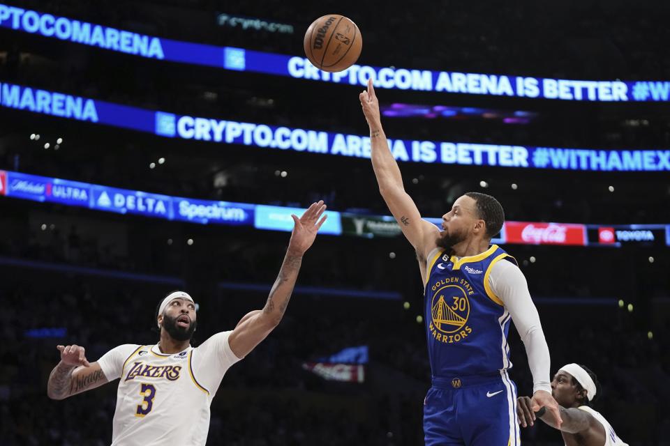 Golden State Warriors guard Stephen Curry, center, shoots as Los Angeles Lakers forward Anthony Davis, left, and forward Jarred Vanderbilt defend during the first half in Game 3 of an NBA basketball Western Conference semifinal Saturday, May 6, 2023, in Los Angeles. (AP Photo/Mark J. Terrill)
