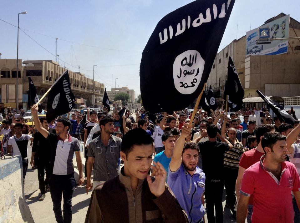 Demonstrators chant pro-Islamic State group slogans as they carry the group's flags in front of the provincial government headquarters in Mosul, 225 miles (360 kilometers) northwest of Baghdad in July 2014. (Photo: AP)