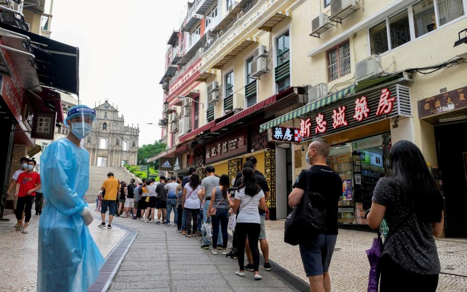 People queue for testing in Macau, China - STRINGER/REUTERS