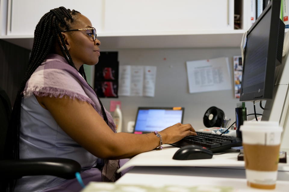 A woman works on her computer as the first phase of FMC Corporation employees return to work in the office in Philadelphia, Pennsylvania, U.S., June 14, 2021. REUTERS/Hannah Beier