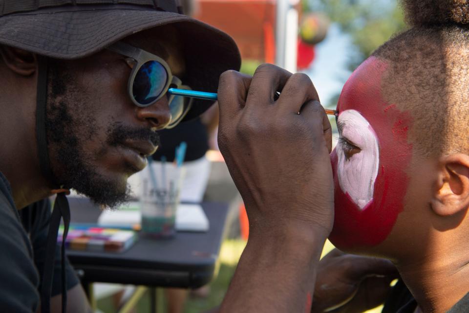 Joshua Pendleton, left, gives Ashtin Black, 8, right, Spiderman face paint at a Juneteenth Block Party in Evansville, Ind., Saturday afternoon, June 18, 2022.