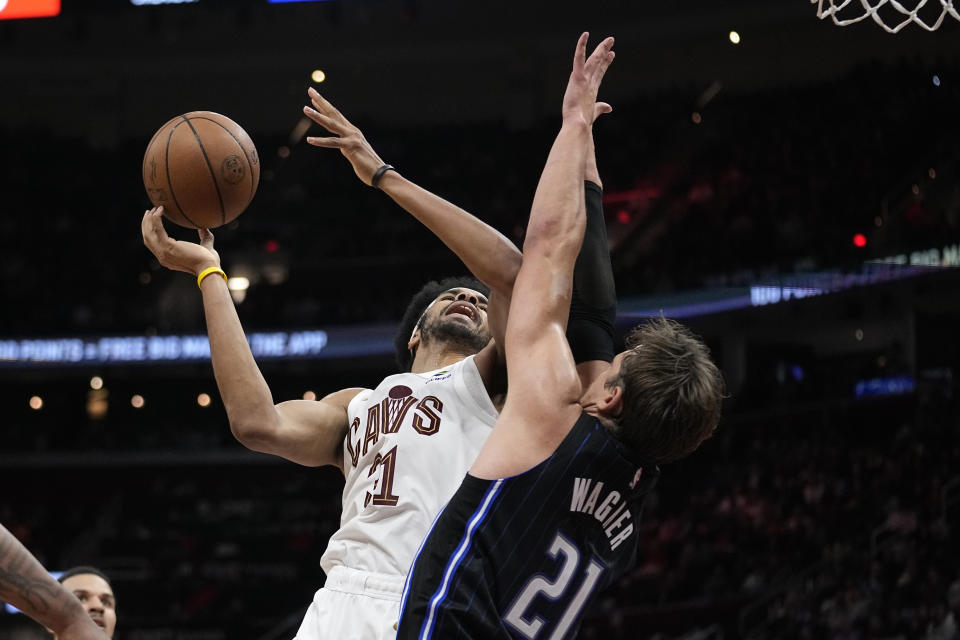 Cleveland Cavaliers center Jarrett Allen, left, shoots as Orlando Magic center Moritz Wagner defends during the second half of an NBA basketball game Thursday, Feb. 22, 2024, in Cleveland. (AP Photo/Sue Ogrocki)