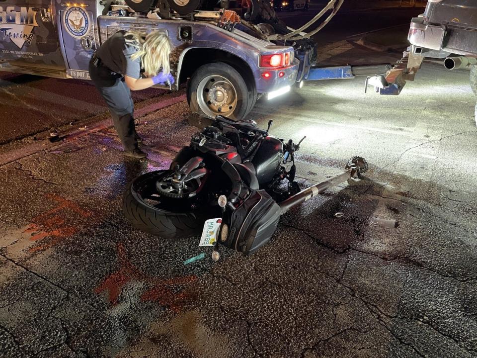 An Ocala Police Department evidence technician takes pictures of a motorcycle that was involved in a crash with a pickup truck on Tuesday night along SW 19th Avenue Road.