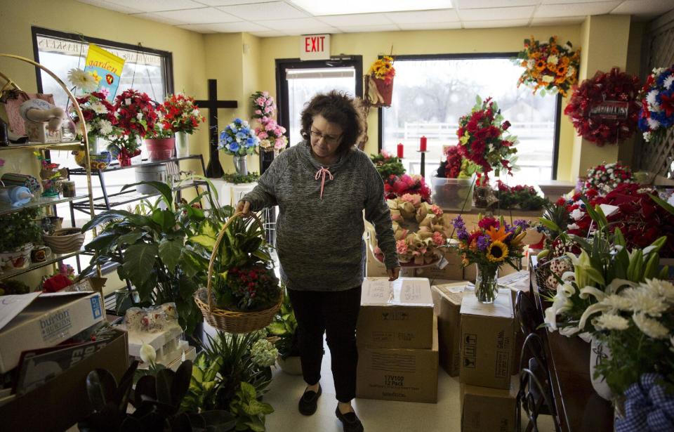 Patti Thomas prepares a flower basket for an order at her floral shop in Lula, Ga., in Hall County, Tuesday, Jan. 10, 2017. Thomas expresses excitement about Donald Trump's upcoming presidency and predicts he will inspire an economic and cultural renaissance. "He's already proven he can turn things around," the 52-year-old says, crediting Trump with Ford Motor Co.'s recent announcement that it would scrap a planned Mexico plant while expanding in Michigan. "Just his business enthusiasm, we've been lacking that." (AP Photo/David Goldman)