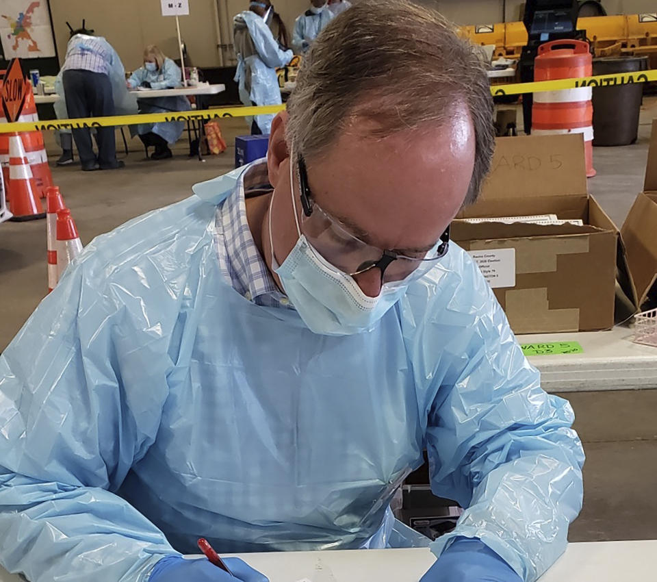 In this photo provided by Robin Vos, the Republican speaker of the Wisconsin Assembly, Vos is shown wearing a mask, gloves and a protective gown while working at the polls in Burlington, Wis., on Tuesday, April 7, 2020. Vos sued Democratic Gov. Tony Evers, who tried to stop the election due to fears of coronavirus, but the Wisconsin Supreme Court said Evers didn't have the authority to stop the election. Vos said the election could be run safely despite public health warnings about the risk of spreading the virus. (Photo courtesy of Robin Vos via AP)