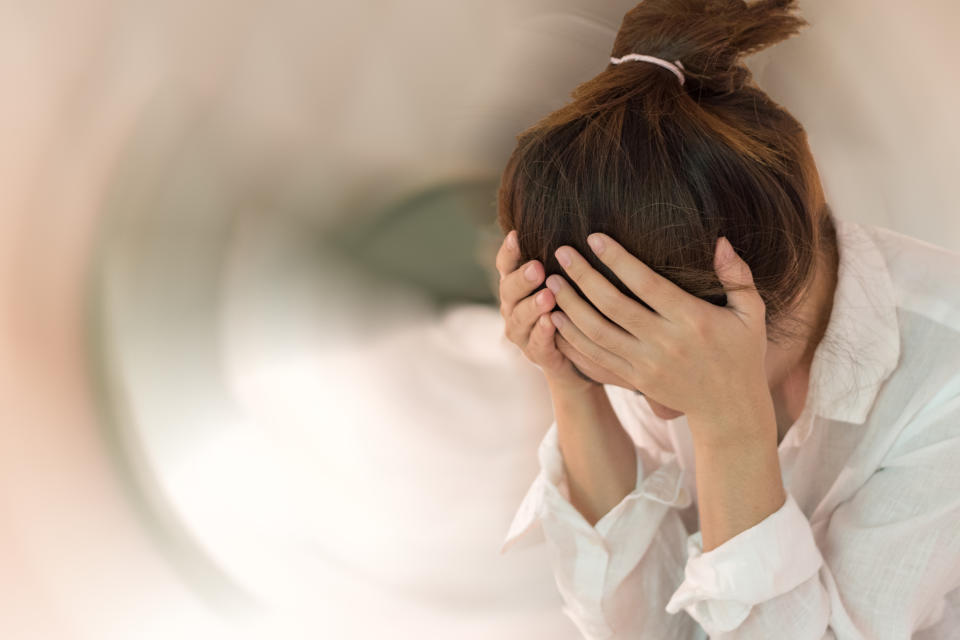 Vertigo illness concept. Woman hands on his head felling headache dizzy sense of spinning dizziness,a problem with the inner ear, brain, or sensory nerve pathway.