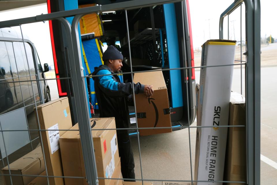 Adam Handy loads packages into delivery truck on March 8. Amazon Rivian electric delivery truck fleet is now in Oklahoma City.