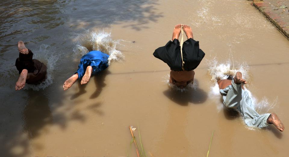 Children swim in puddles to escape heat in Jacobabad, Pakistan.