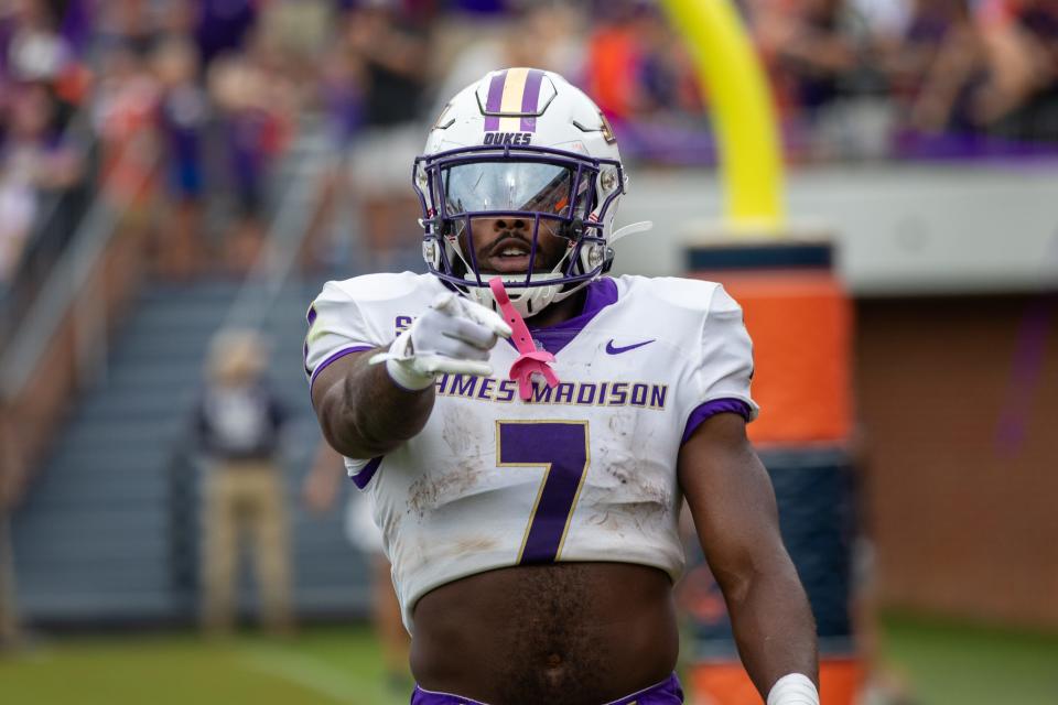 Dukes running back Ty Son Lawton points at the camera after scoring a touchdown against the Virginia Cavaliers.