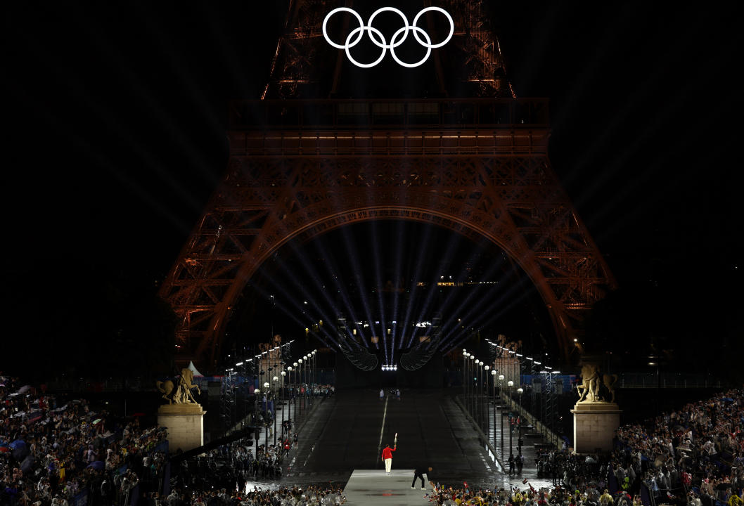 PARIS, FRANCE - JULY 26: 14-time French Open winner Rafael Nadal of Team Spain holds the torch during the opening ceremony of the Olympic Games Paris 2024 on July 26, 2024 in Paris, France. (Photo by Jamie Squire/Getty Images)