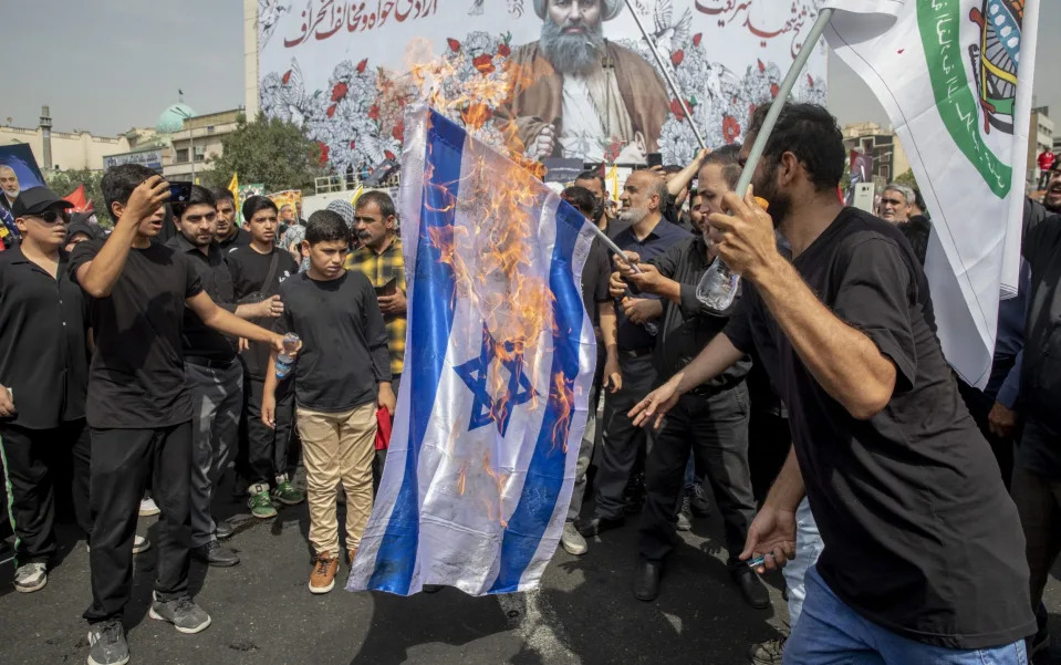 Iranians burn the Israeli flag during the funeral ceremony of Ismail Haniyeh, the Hamas leader