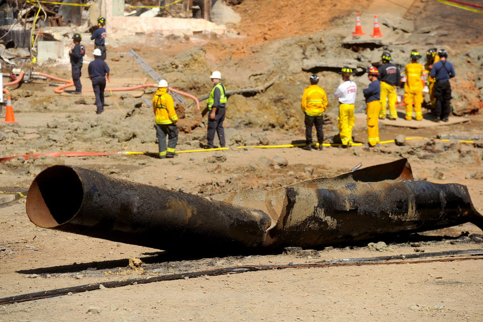 FILE - In this Sept. 11, 2010, file photo, a natural gas line lies broken on a San Bruno, Calif., road after a massive explosion. Pacific Gas & Electric Co. pleaded not guilty Monday, April 21, 2014, to a dozen felony charges stemming from alleged safety violations in a deadly 2010 natural gas pipeline explosion that leveled a suburban neighborhood in the San Francisco Bay Area. As survivors of the blast looked on, attorneys for California's largest utility entered the plea in federal court in San Francisco to 12 felony violations of federal pipeline safety laws. (AP Photo/Noah Berger, File)
