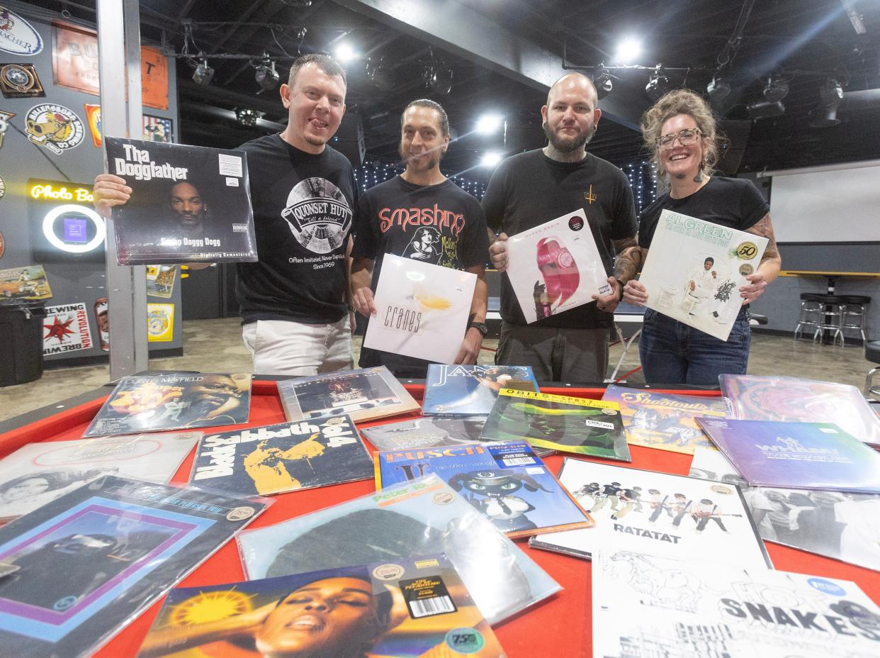 Quonset Hut co-owner Matt Hisrich, far left, Kyle Laudermilt, Quonset Hut vinyl buyer, Josh Brewer, owner of The Auricle, and Sam Heaton, owner of Erie St Vinyl, pose with records at The Auricle, where Vinyl Revival: Stark County's Record Swap & Shop event will be on Saturday in downtown Canton.