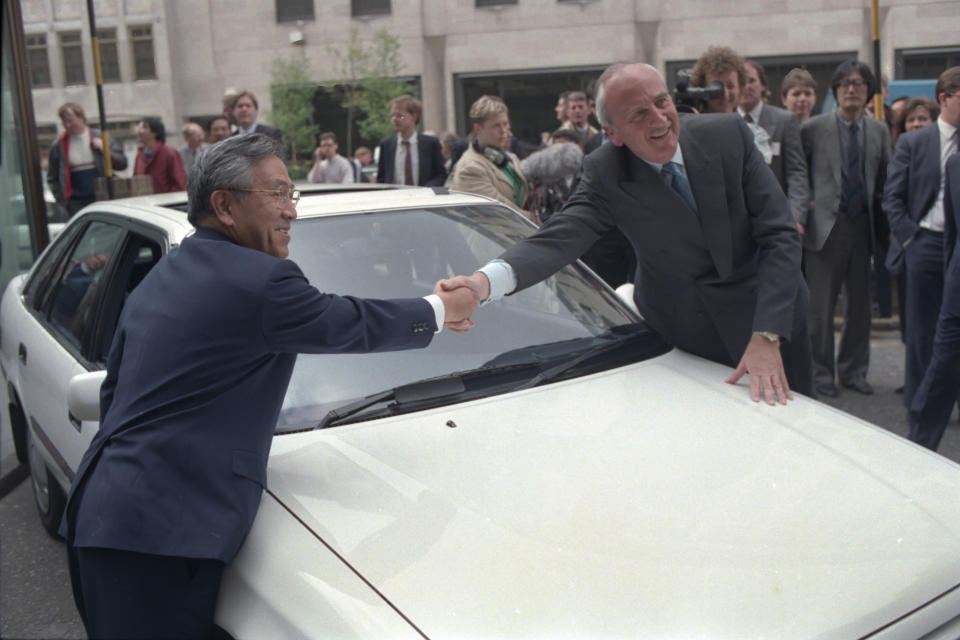 FILE - Britain's Trade Secretary Lord Young shakes hands with Shoichiro Toyoda, then president of Toyota Motors, right, over the hood of a Toyota car in London Tuesday, April 18, 1989. Toyoda, who as a son of the company's founder oversaw Toyota's expansion into international markets has died. He was 97. (AP Photo/Dave Caulkin, File)