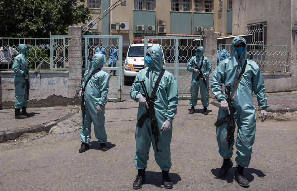 Palestinian Hamas police officers wear protective suits as they take part in a simulation of possible coronavirus infections in Gaza City, Saturday, July 18, 2020. (AP Photo/Khalil Hamra)