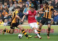 Hull City's Ahmed Elmohamady (R) and James Chester challenge Arsenal's Mesut Ozil, at the KC Stadium in Hull, on April 20, 2014