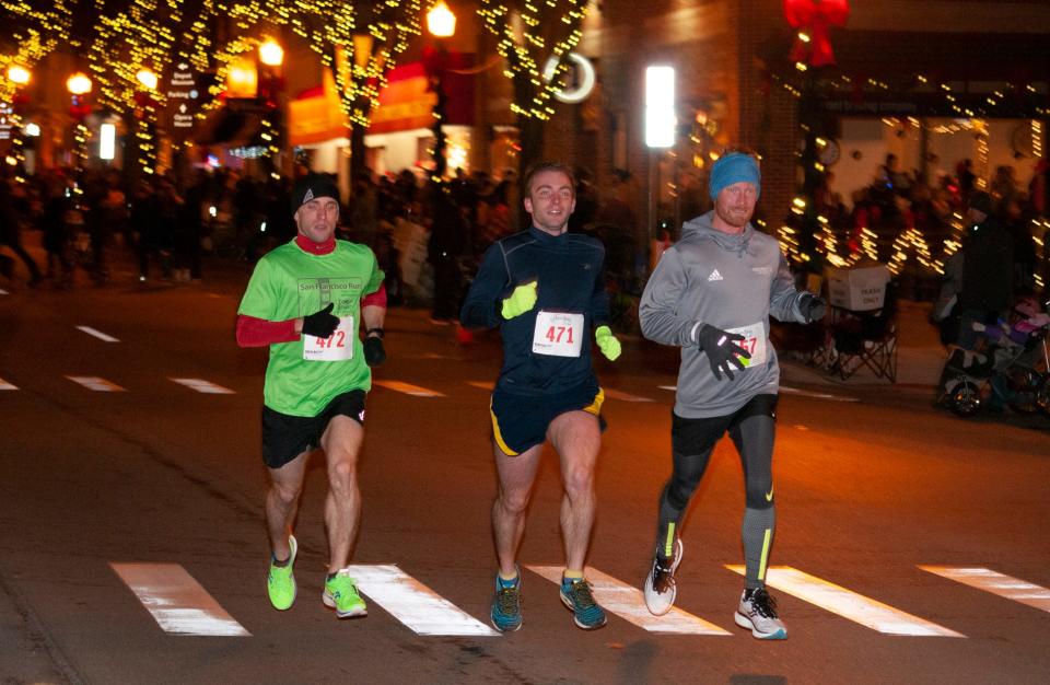 From left, Tyler Partridge, Josh Partridge and Mitchell Griest race together in the Fantasy of Lights 5K Friday, Nov. 26, 2021. Tyler Partridge won in 16:26.