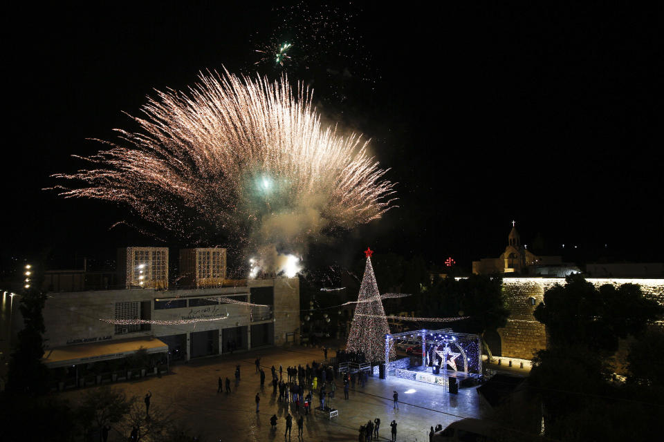 Palestinian Christians attend the lighting of a Christmas tree outside the Church of the Nativity, traditionally believed by Christians to be the birthplace of Jesus Christ in the West Bank city of Bethlehem, Saturday, Dec. 5, 2020. (AP Photo/Majdi Mohammed)