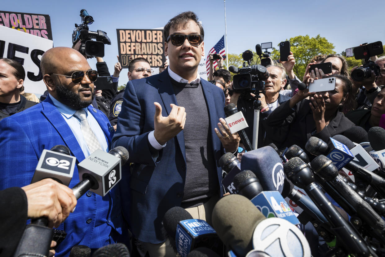 U.S. Rep. George Santos speaks to the media alongside his top political aide Vish Burra, left, outside the federal courthouse in Central Islip, N.Y on Wednesday, May 10, 2023. (AP Photo/Stefan Jeremiah, File)
