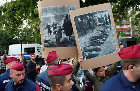 Counter-demonstrators hold placards depicting Roma Holocaust as members of far-right, nationalist groups attend a protest against criminal attacks caused by youth, in Torokszentmiklos, Hungary, May 21, 2019. REUTERS/Bernadett Szabo