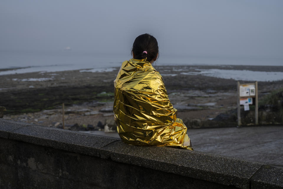 A woman and a child, both Kurdish migrants, rest after a failed attempt to reach the United Kingdom by boat, as they were discovered by the police in Ambleteuse, in northern France, on Sunday, May 19, 2024. (AP Photo/Bernat Armangue)