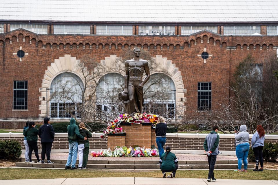 People leave flowers at the base of the Sparty statue on Tuesday, February 14, 2023, following an active shooting incident the night before on the Michigan State University campus in East Lansing that left three people dead and multiple injured.