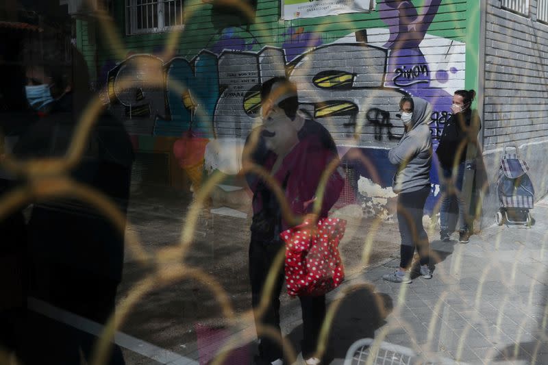 People queue to receive donated food from volunteers of Vecinos Parque Aluche association as the spread of the coronavirus disease (COVID-19) continues in Madrid